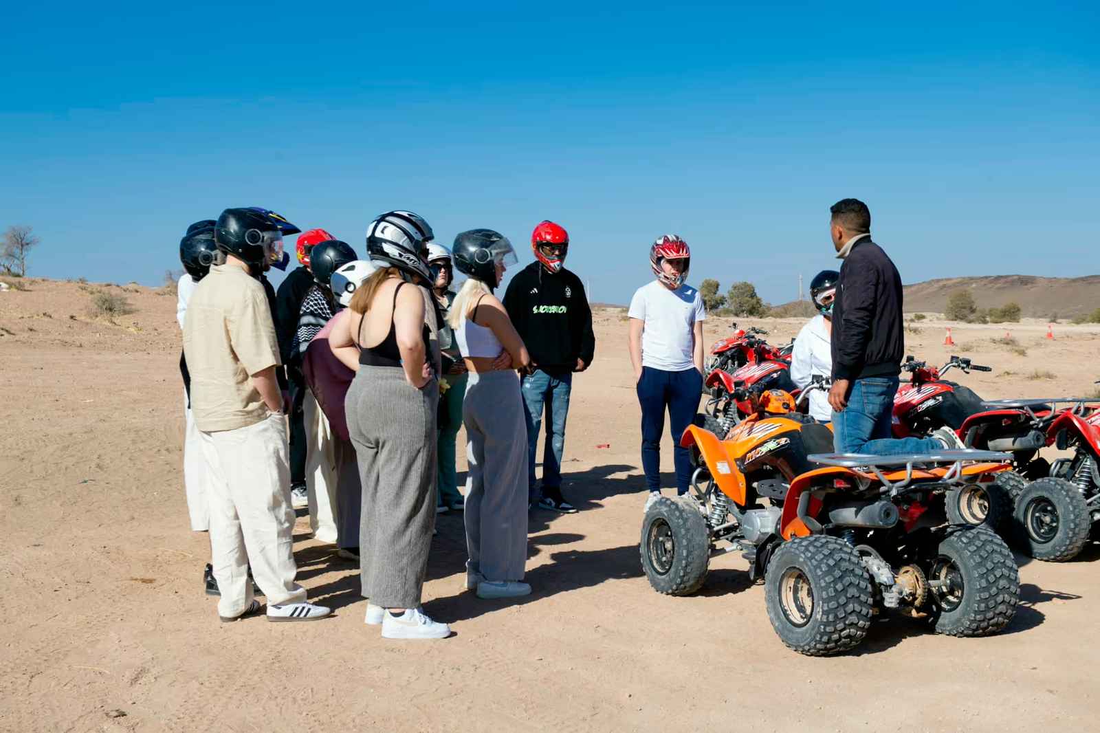 Riders in helmets gathered beside the quads before the start