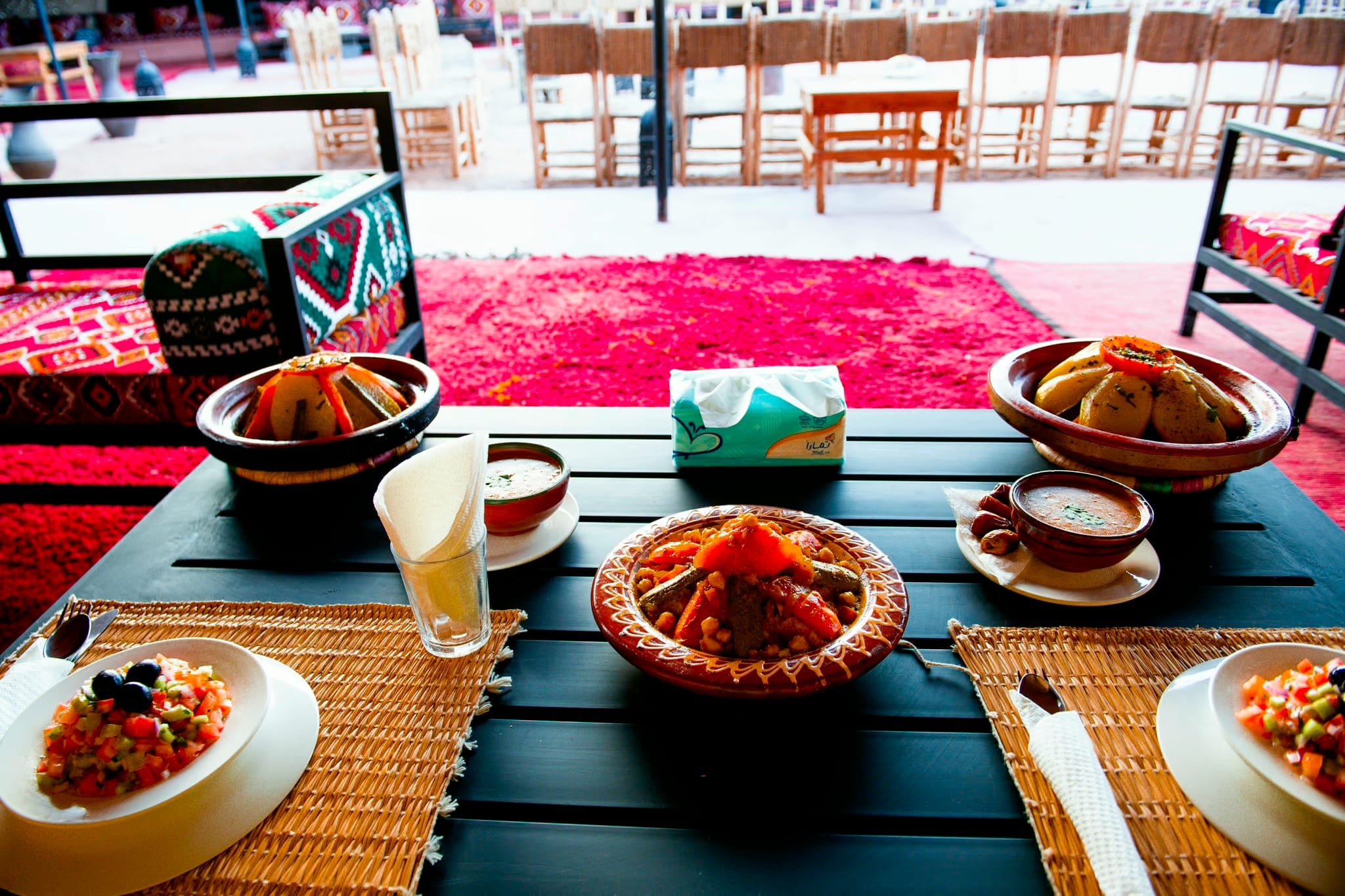 Tisch mit Tajines, Salat und Minztee